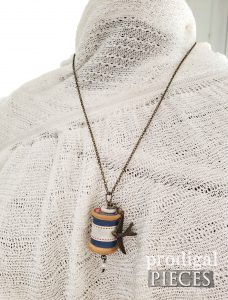 Brass Bird Charm with Blue Accent Ribbon on Wooden Spool Necklace | shop.prodigalpieces.com